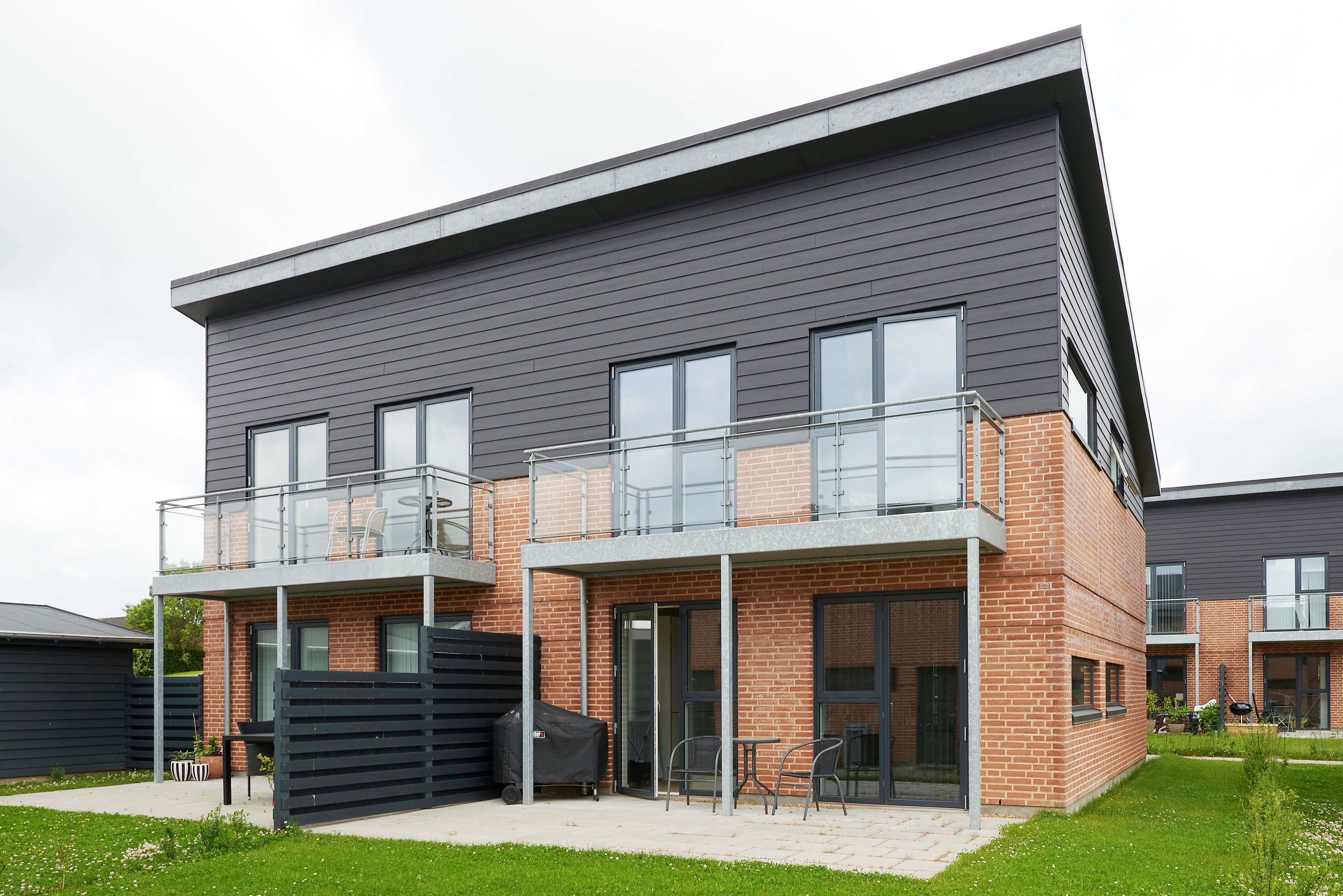 Haus mit Backsteinfassade und schwarzem HardiePlank
